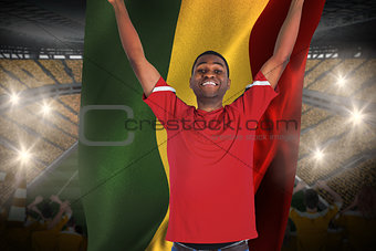 Excited handsome football fan cheering holding ghana flag
