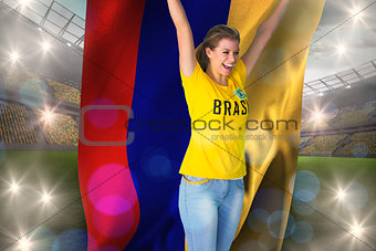 Excited football fan in brasil tshirt holding colombia flag
