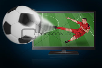 Fit football player playing and kicking ball out of tv