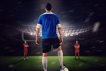 Handsome football player in blue jersey facing opposition