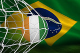 Football in ivory coast colours at back of net