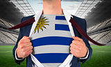 Businessman opening shirt to reveal uruguay flag