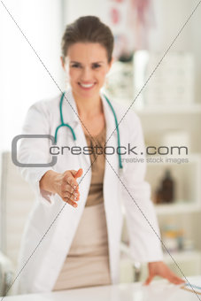 Closeup on smiling medical doctor woman in office stretching han