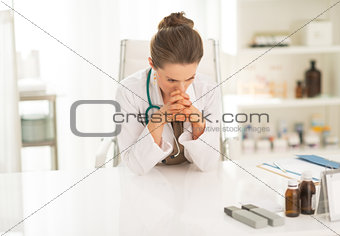 Concerned medical doctor woman sitting in office