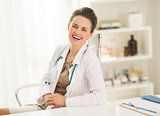 Portrait of laughing medical doctor woman sitting in office