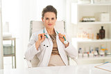 Portrait of happy medical doctor woman sitting in office