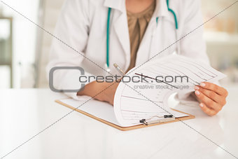 Closeup on medical doctor woman writing in clipboard