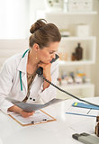 Thoughtful medical doctor woman with fluorography and holding ph