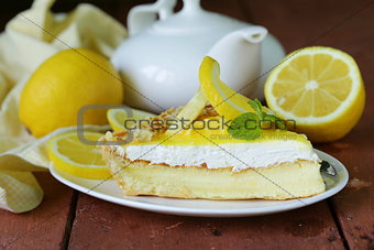 piece of lemon cake tart decorated with fresh lemon and mint