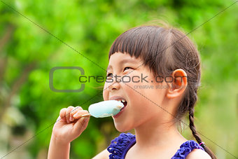 happy little girl eating popsicle at summertime