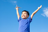 joyful little boy holding a toy with blue sky background