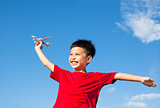 happy boy holding a airplane toy with blue sky background
