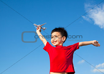 happy boy holding a airplane toy and open arms