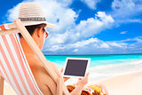 relaxed man sitting on beach chairs and touching tablet