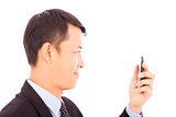 smiling young businessman holding a smartphone and watching