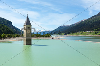 The bell tower in Reschensee and family (Italy).