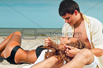 happy couple sitting on the beach
