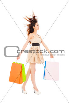 young woman with shopping bags and walking