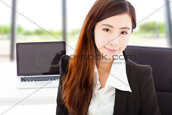 young confident businesswoman sitting in her office