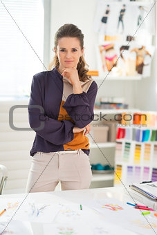 Portrait of thoughtful fashion designer in office