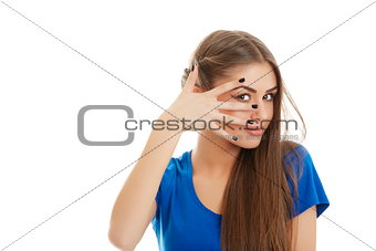 Young woman peeking through fingers