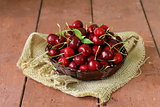 fresh red ripe cherries in wicker basket on a wooden table