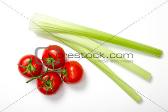 Top view of bunch of fresh tomatoes and celery sticks 
