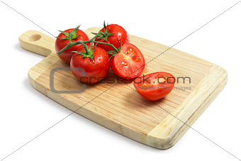 Fresh tomatoes on wooden chopping board  