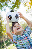 Cute Young Boy Playing with Soccer Ball in Park