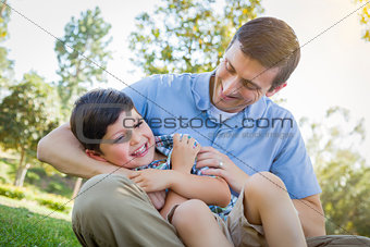 Loving Father Tickling Son in the Park