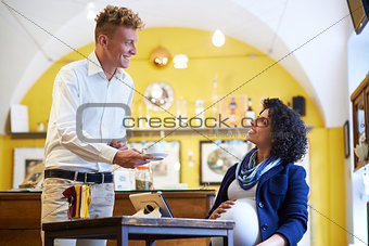 pregnant woman drinking espresso coffee in bar