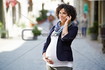 happy pregnant woman talking on the phone