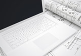 Scrolls of architectural drawings and laptop