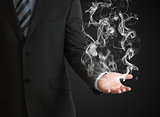 Businessman in a suit holds smoke