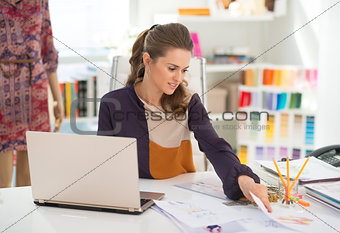 Fashion designer with laptop working in office