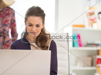 Fashion designer working on laptop in office