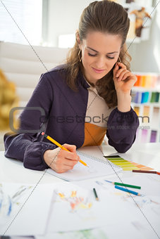Fashion designer making sketches in office