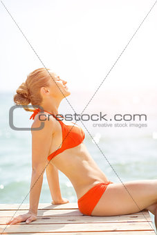 Relaxed young woman sitting on bridge