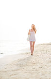 Young woman walking on beach in the evening