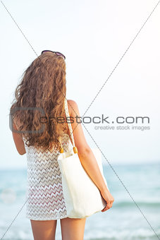 Young woman looking on sea. rear view