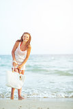 Full length portrait of happy young woman at seaside in the even