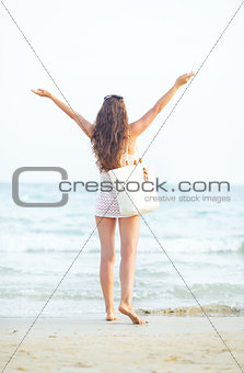 Young woman on beach in the evening rejoicing