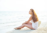 Young woman sitting on beach in the evening
