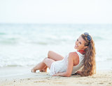 Happy young woman laying on beach in the evening