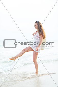 Young woman playing with water on beach