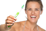 Closeup on happy young woman showing toothbrushâ