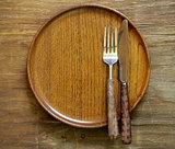 cutlery (knife and fork) on wooden plate