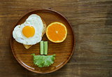 funny face serving breakfast, fried egg, toast and green salad