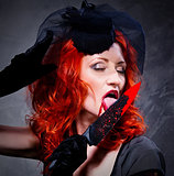 Gorgeous redhead woman with bloody knife in her hand close-up