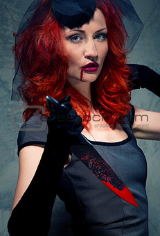 Redhead woman with blood on her lips and bloody knife in hand
